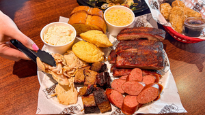 Plate of smoked brisket, ribs, and sides from Smokey D’s BBQ in Des Moines, available for fast and flavorful barbecue takeout near me