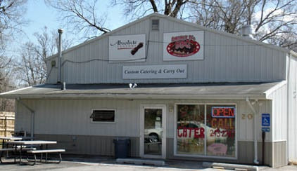 Small building with signs for 'Brockleberry's' and 'Custom Catering & Carry Out', with a clear sky background.
